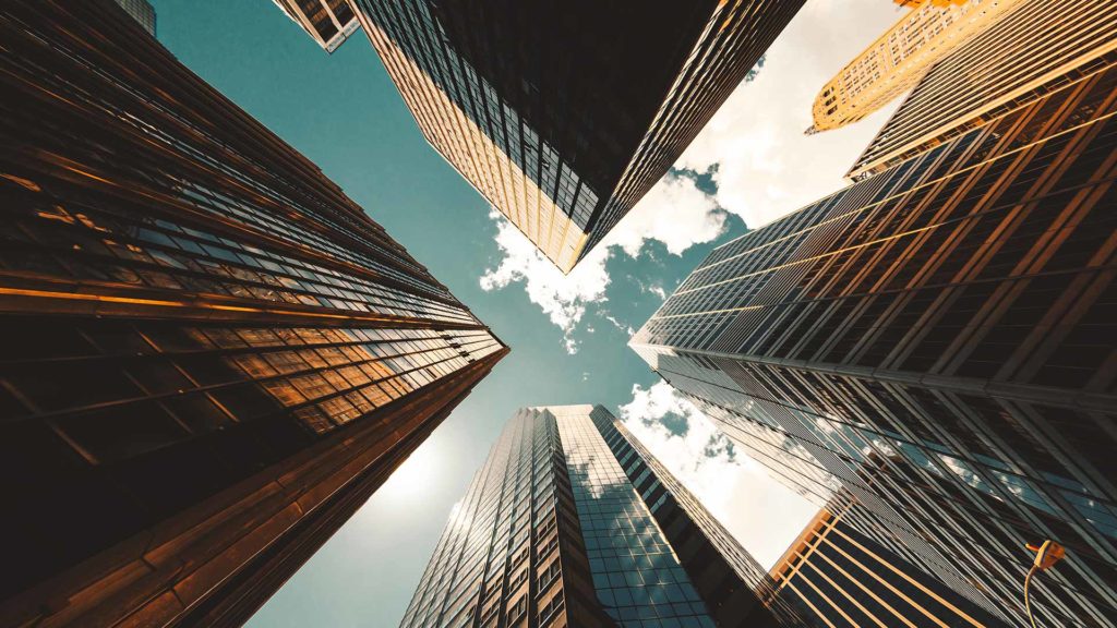 Tops of tall skyscrapers with blue sky peeking through