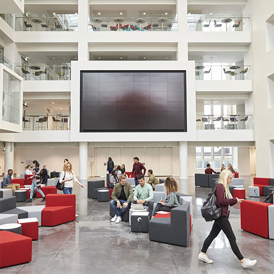 People sitting and conversing in common space of large office building