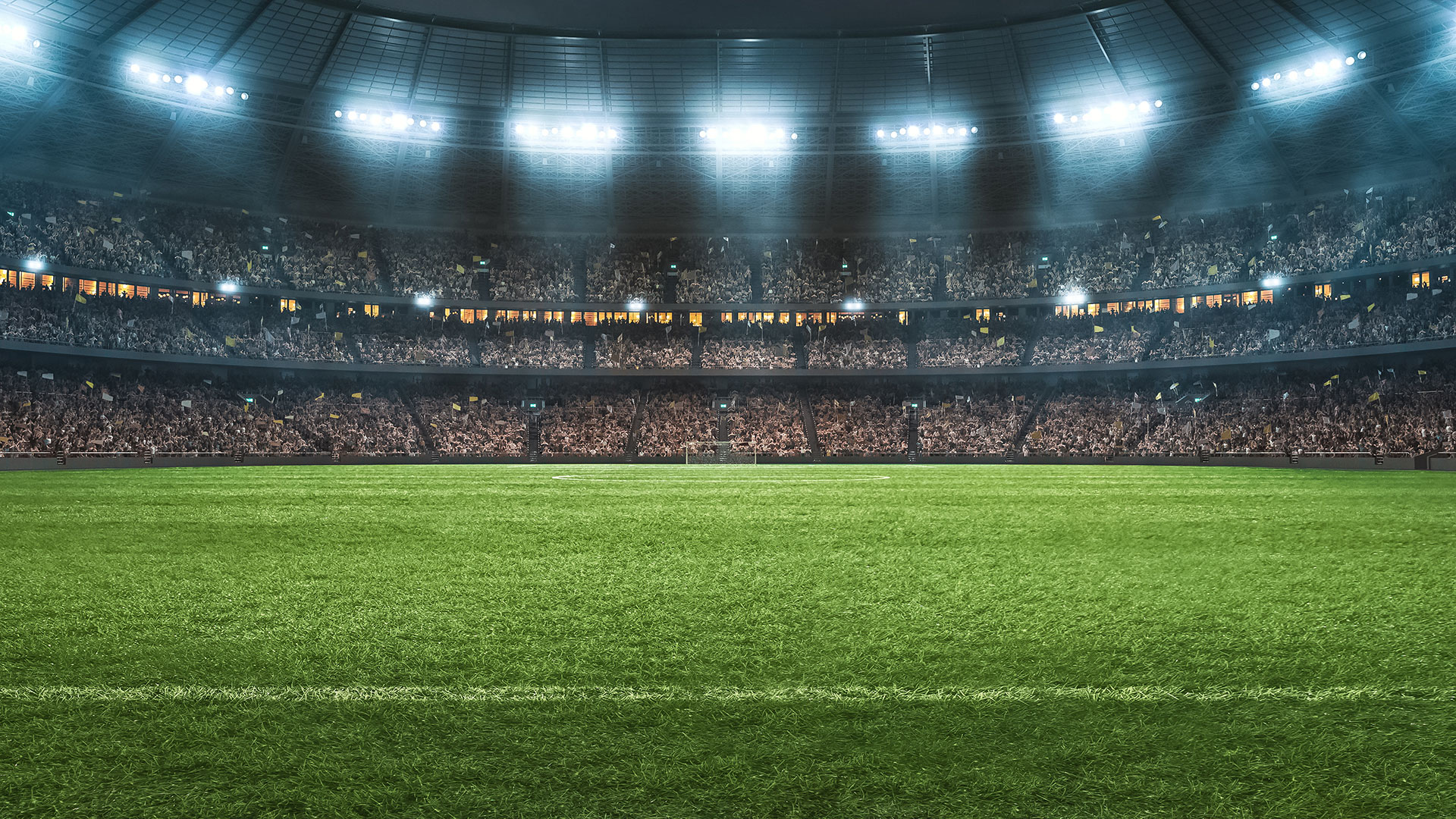 Interior of stadium with lights, the field, and crowded stands